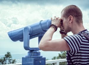 man preforming looking through binoculars